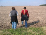 two people walking through a field