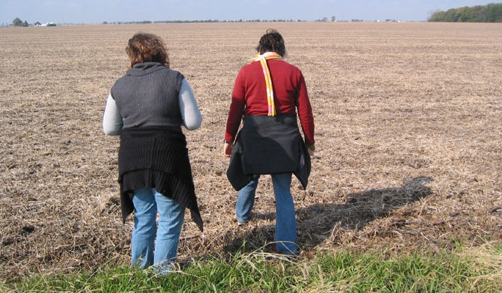two people walking through a field